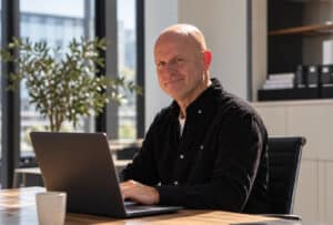 Ivo Dekkers van KNDIT achter zijn laptop op kantoor